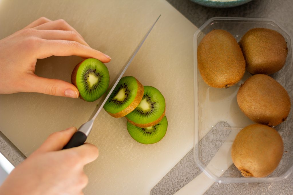 Slicing kiwi fruit on a cutting board